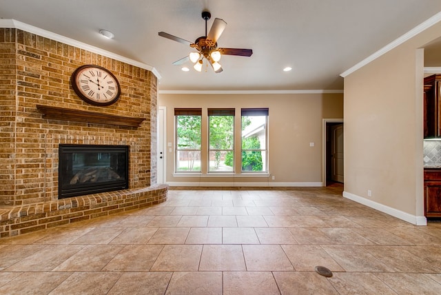 unfurnished living room with a brick fireplace, a ceiling fan, crown molding, and baseboards