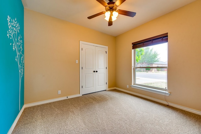 empty room featuring ceiling fan, baseboards, and carpet floors