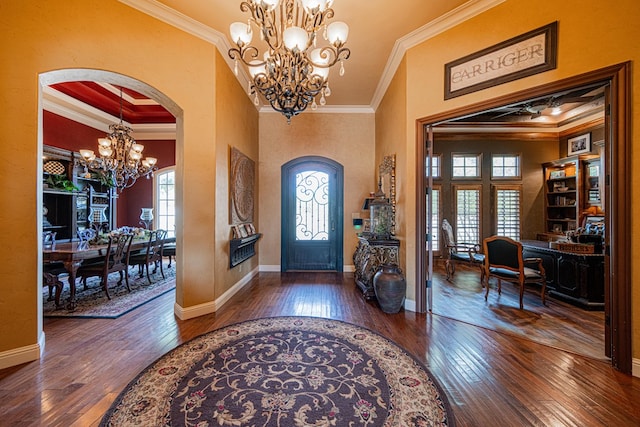 entrance foyer featuring a chandelier, crown molding, plenty of natural light, hardwood / wood-style floors, and arched walkways
