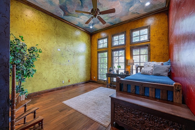 bedroom with ornamental molding, wood finished floors, and baseboards