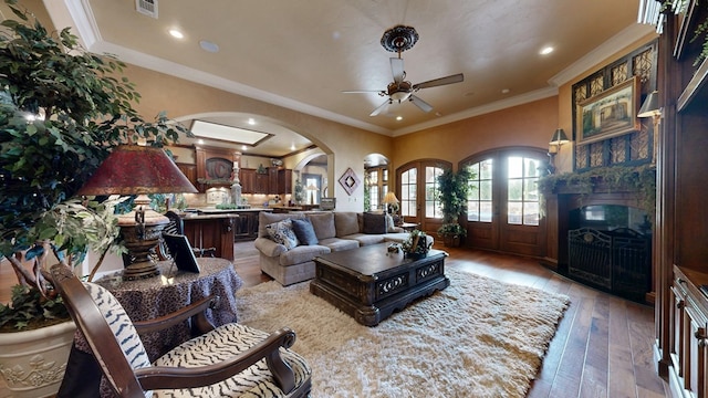 living room with a ceiling fan, light wood-type flooring, arched walkways, a fireplace, and recessed lighting