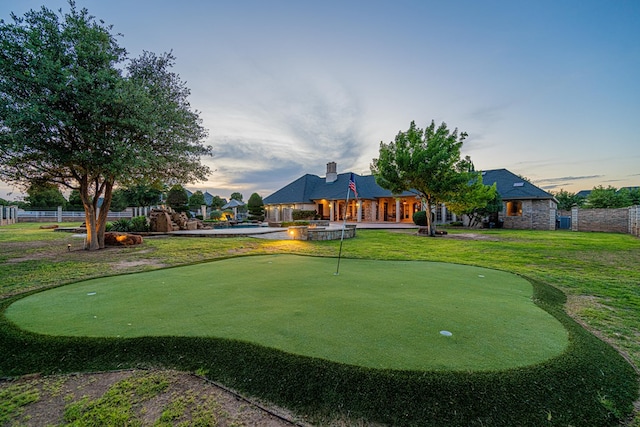 view of property's community with a putting area, fence, and a patio area
