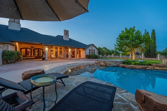 view of swimming pool with french doors, a patio area, fence, a pool with connected hot tub, and a ceiling fan