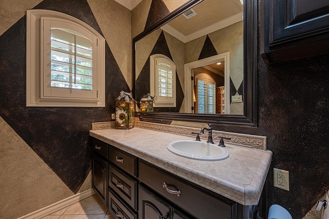 bathroom with crown molding, vanity, tile patterned floors, and a textured wall