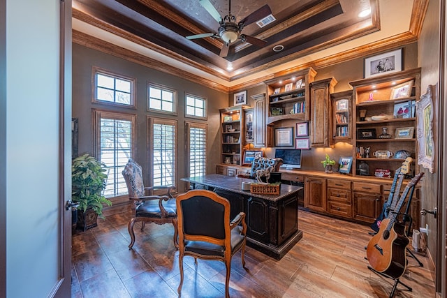 office space with crown molding, a tray ceiling, built in study area, a ceiling fan, and a high ceiling