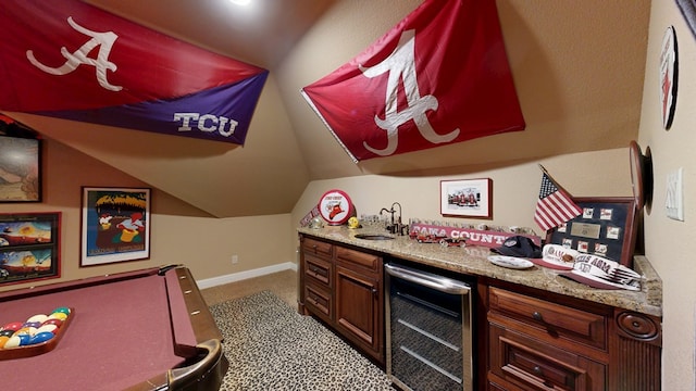 indoor wet bar featuring wine cooler, vaulted ceiling, carpet flooring, and baseboards
