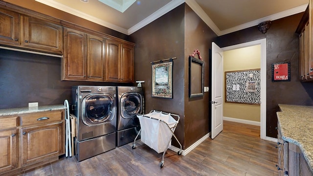 clothes washing area featuring cabinet space, washer and dryer, dark wood-type flooring, ornamental molding, and baseboards