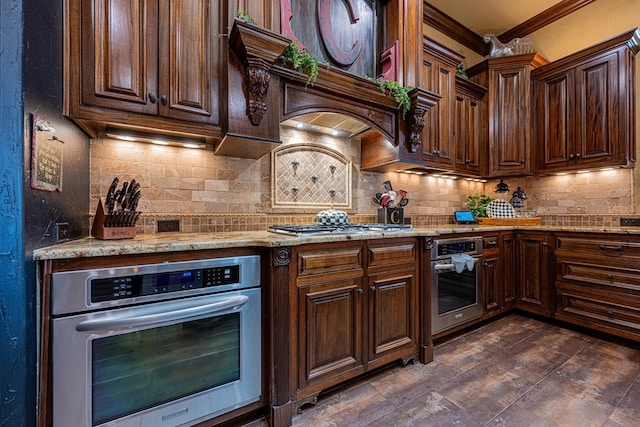 kitchen featuring stainless steel appliances, decorative backsplash, light stone countertops, crown molding, and dark brown cabinets