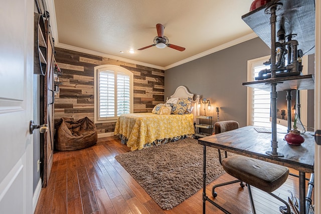 bedroom featuring ornamental molding, wood walls, hardwood / wood-style floors, and ceiling fan