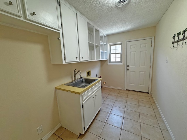 3619 W Wadley Ave, Midland, TX 79707 - laundry room featuring hookup for an electric dryer, washer hookup, cabinet space, a textured ceiling, and light tile patterned floors