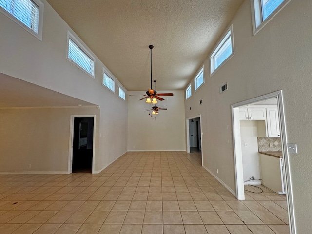 3619 W Wadley Ave, Midland, TX 79707 - unfurnished room with a towering ceiling, ceiling fan, healthy amount of natural light, light tile patterned floors, and a textured ceiling