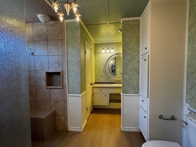 3619 W Wadley Ave, Midland, TX 79707 - bathroom with wood finished floors, a wainscoted wall, vanity, tiled shower, and a chandelier