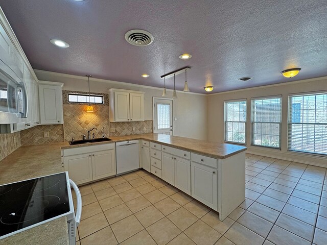 3619 W Wadley Ave, Midland, TX 79707 - kitchen featuring white appliances, decorative backsplash, a peninsula, light tile patterned floors, and light countertops