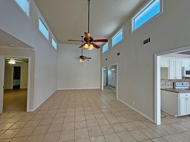 3619 W Wadley Ave, Midland, TX 79707 - empty room featuring ceiling fan, a high ceiling, a textured ceiling, and light tile patterned floors