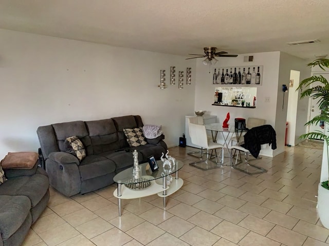 tiled living room featuring a textured ceiling and ceiling fan