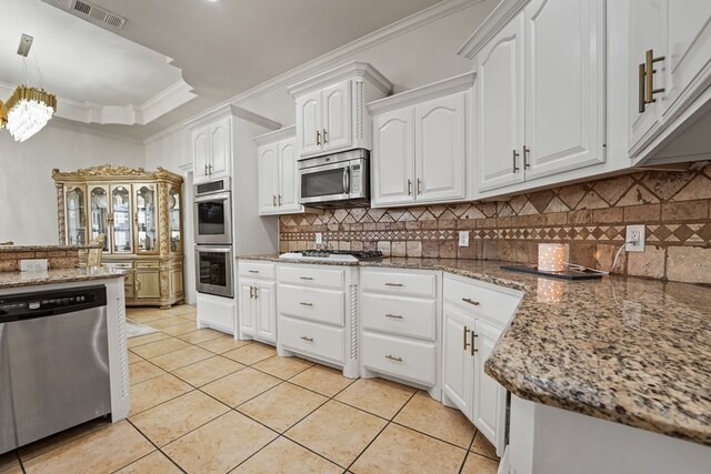 4626 Crockett Ave, Midland, TX 79703 - kitchen with stainless steel appliances, light tile patterned floors, visible vents, ornamental molding, and white cabinets