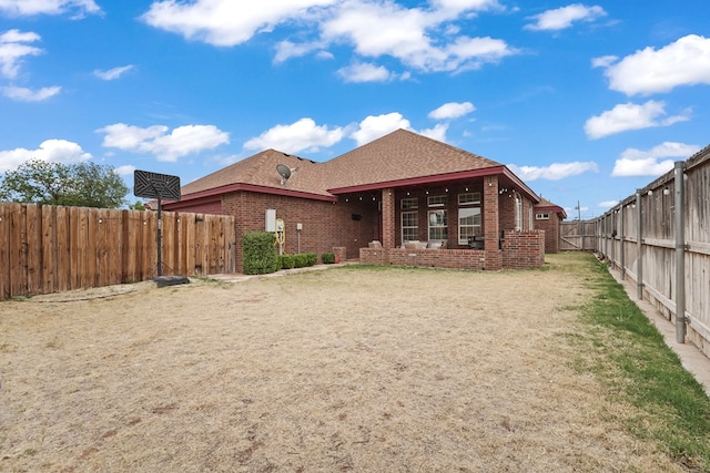 4626 Crockett Ave, Midland, TX 79703 - rear view of property featuring brick siding, a fenced backyard, a shingled roof, and a lawn