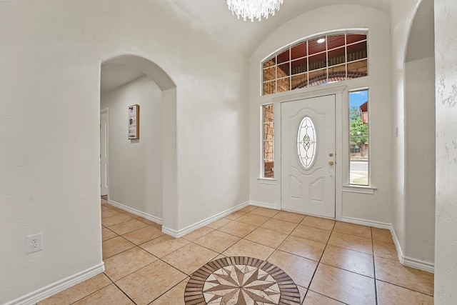 4626 Crockett Ave, Midland, TX 79703 - entrance foyer with arched walkways, light tile patterned flooring, an inviting chandelier, and baseboards