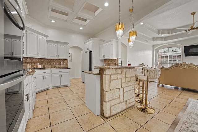 4626 Crockett Ave, Midland, TX 79703 - kitchen featuring light tile patterned floors, fridge, a peninsula, and arched walkways
