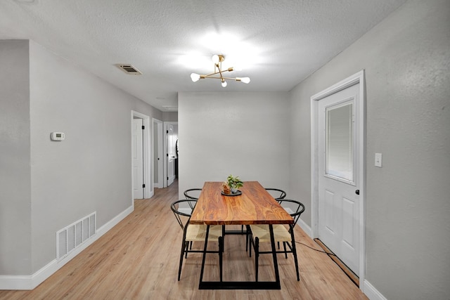 1000 S Jefferson St, Midland, TX 79701 - dining area with light wood-style floors, baseboards, a chandelier, and a textured ceiling