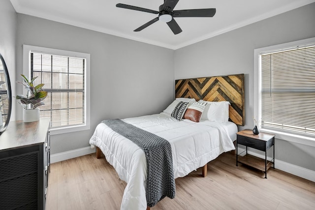 bedroom with ornamental molding, light wood-type flooring, baseboards, and a ceiling fan