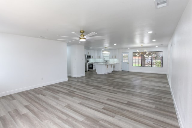 2702 Ann Dr, Big Spring, TX 79720 - unfurnished living room featuring a chandelier, recessed lighting, ceiling fan, and light wood finished floors