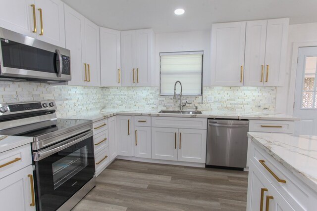 2702 Ann Dr, Big Spring, TX 79720 - kitchen featuring stainless steel appliances, white cabinetry, tasteful backsplash, recessed lighting, and light stone countertops