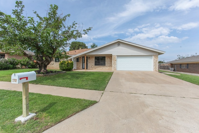 2702 Ann Dr, Big Spring, TX 79720 - ranch-style house featuring brick siding, a front yard, driveway, and an attached garage