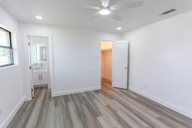 2702 Ann Dr, Big Spring, TX 79720 - unfurnished bedroom featuring wood finished floors, a walk in closet, recessed lighting, connected bathroom, and ceiling fan