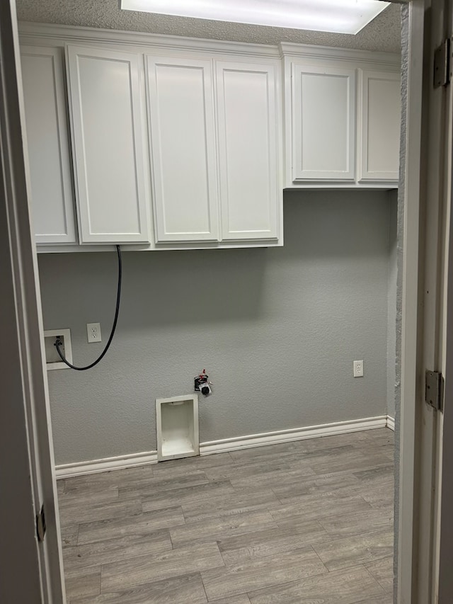 laundry room with cabinet space, hookup for a washing machine, gas dryer hookup, baseboards, and wood finished floors