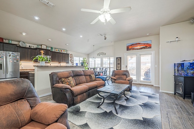 living room featuring ceiling fan, vaulted ceiling, light hardwood / wood-style flooring, and a wealth of natural light