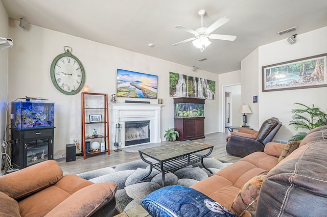 living room with ceiling fan and light hardwood / wood-style flooring