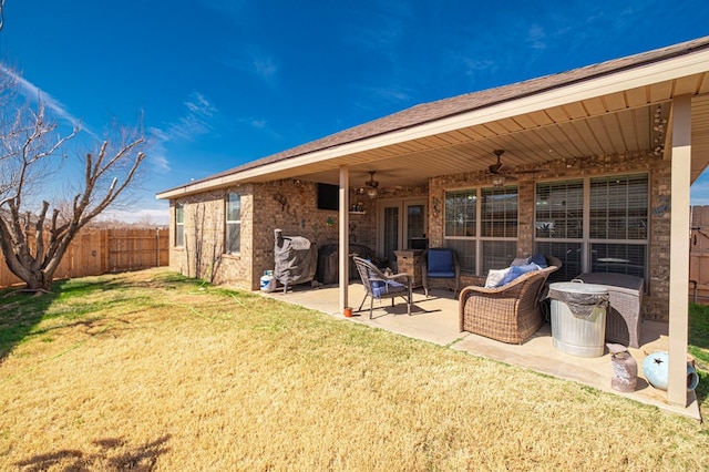 rear view of property featuring ceiling fan, a yard, an outdoor hangout area, and a patio area