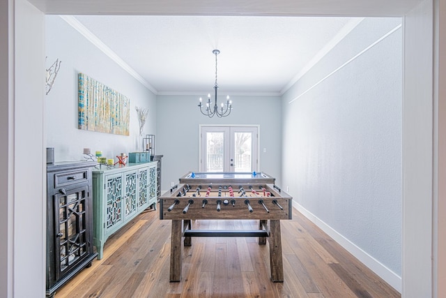 rec room with hardwood / wood-style floors, crown molding, and french doors