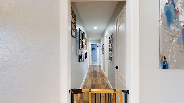 hallway with wood finished floors and recessed lighting