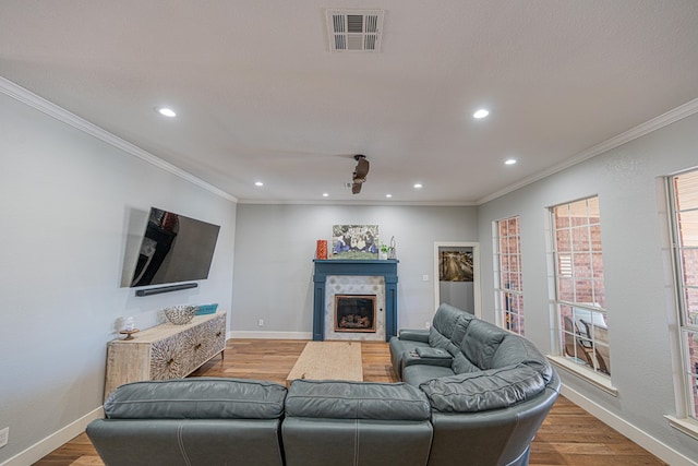 living area featuring crown molding, visible vents, and wood finished floors