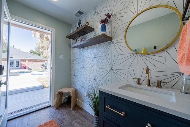 interior space with visible vents, vanity, and wood finished floors