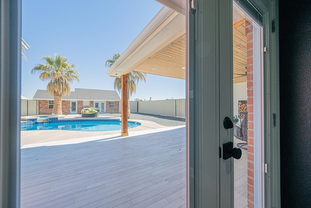 view of pool with a pool with connected hot tub, fence, and a patio