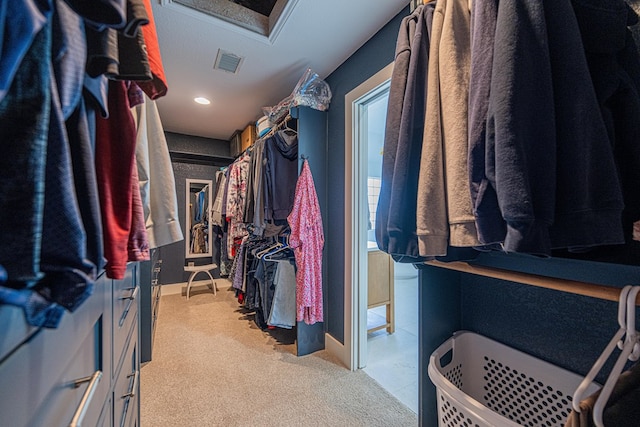 spacious closet featuring light carpet, attic access, and visible vents