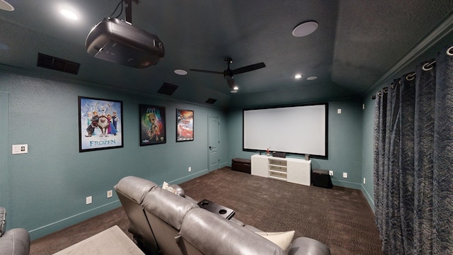 carpeted home theater room featuring baseboards, visible vents, ceiling fan, and ornamental molding