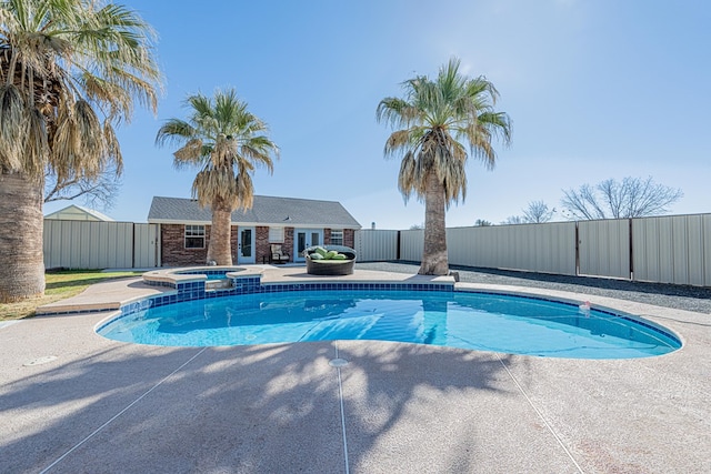 view of swimming pool featuring a pool with connected hot tub, a patio area, and fence