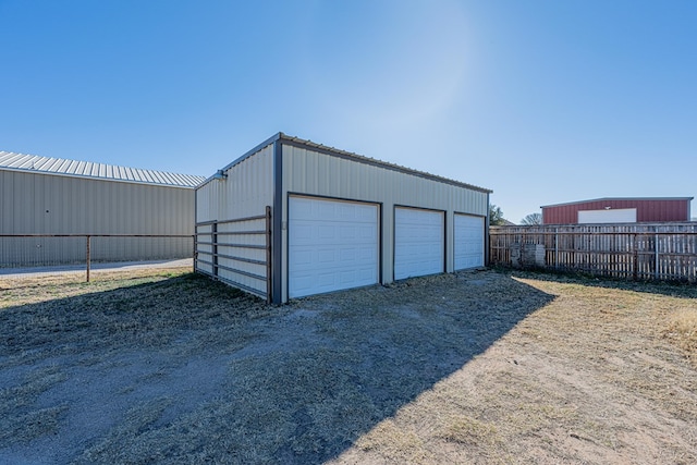 detached garage featuring fence