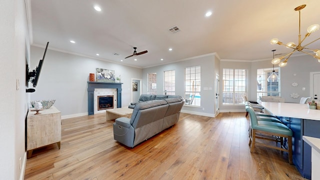 living area featuring light wood-style floors, baseboards, a fireplace, and visible vents