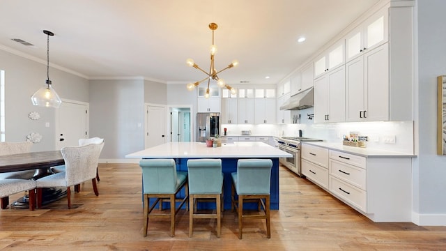 kitchen with ornamental molding, stainless steel appliances, light wood-type flooring, under cabinet range hood, and white cabinetry