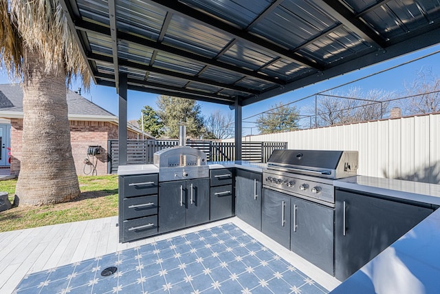 view of patio with fence, a deck, and area for grilling