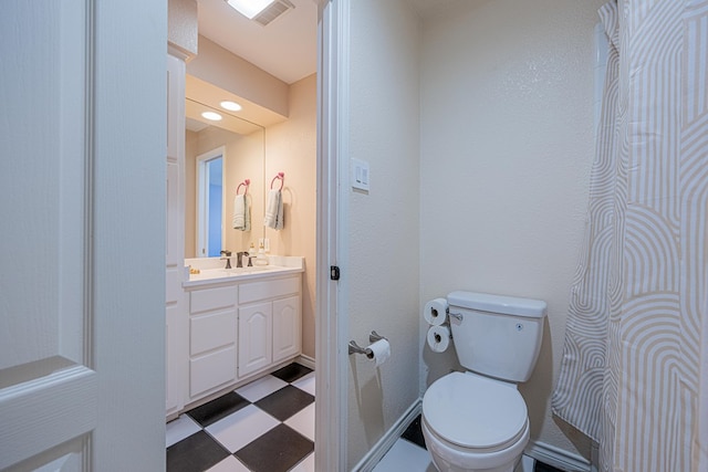 bathroom with visible vents, vanity, toilet, and tile patterned floors