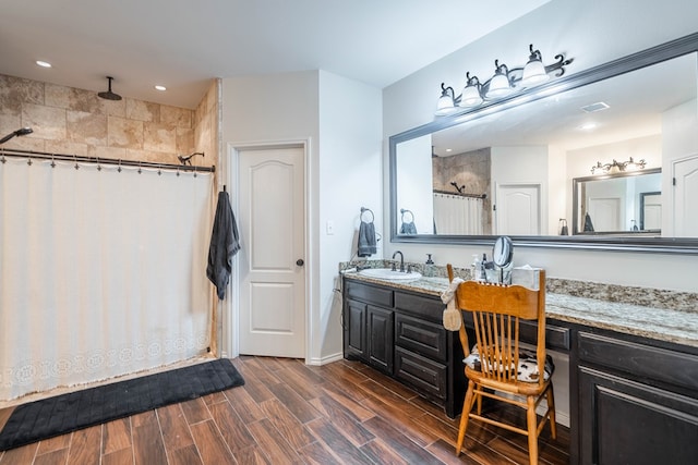 5305 Deer Run, Midland, TX 79707 - bathroom with a tile shower, double vanity, wood finished floors, and recessed lighting
