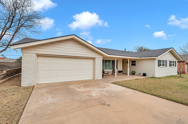 single story home with an attached garage, brick siding, fence, concrete driveway, and a front yard