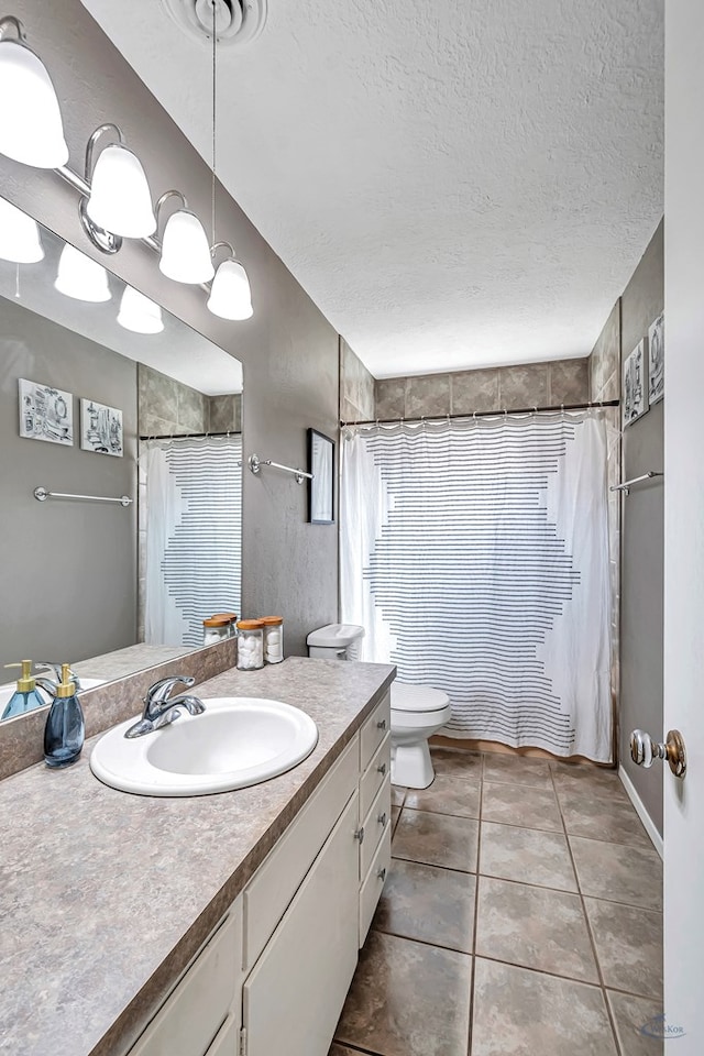 full bathroom with a textured ceiling, toilet, a shower with shower curtain, vanity, and tile patterned floors