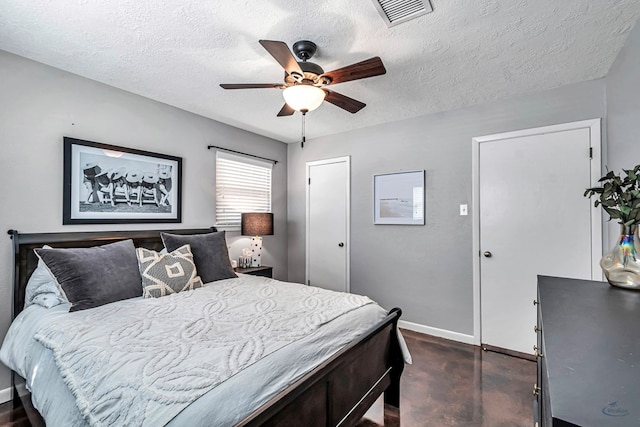 bedroom with a textured ceiling, a ceiling fan, visible vents, and baseboards